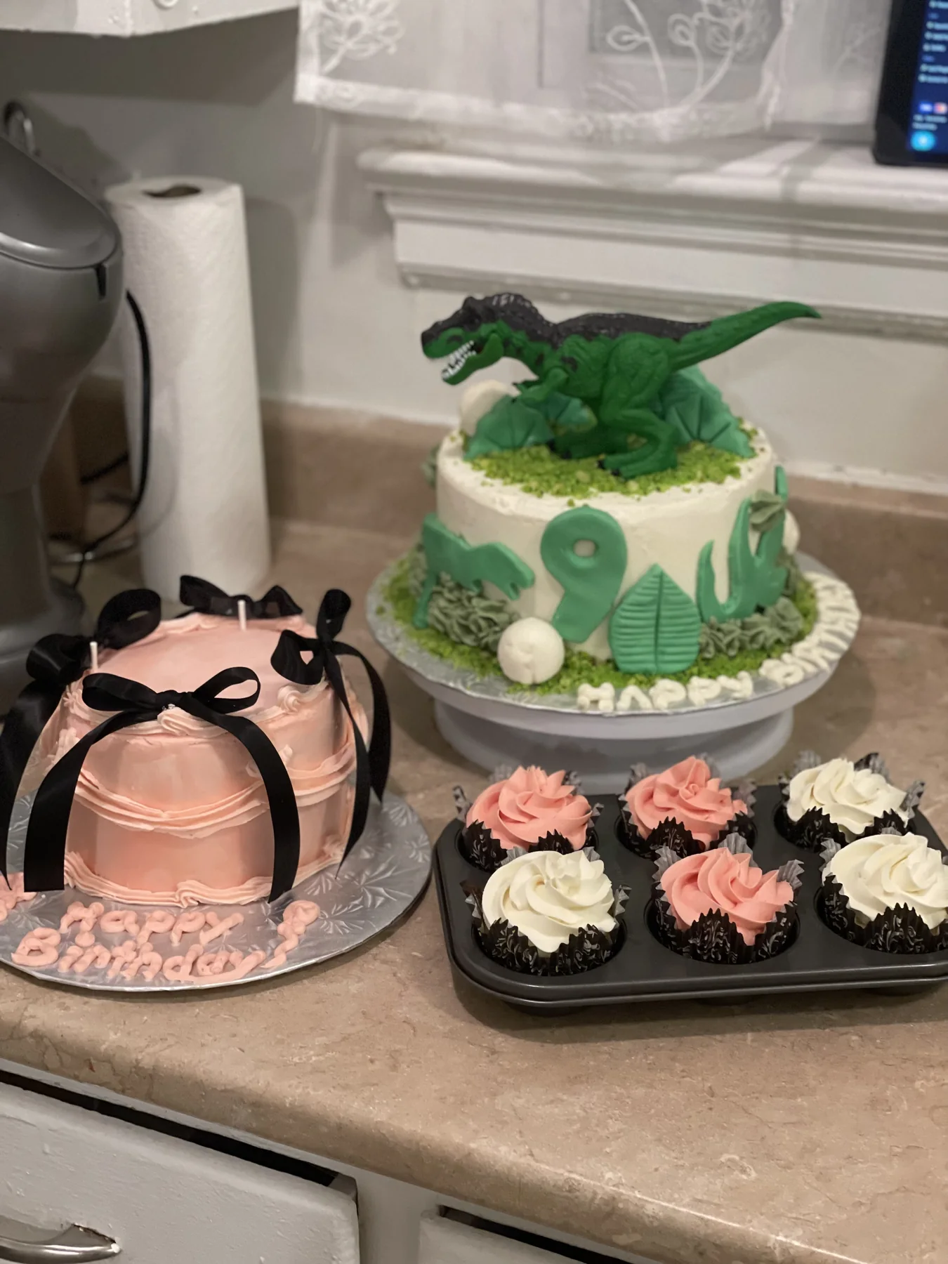 Custom cakes and matching cupcakes arranged in Hibaq's kitchen